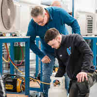 Twee medewerkers in een fabriek die werken aan een gaskraan