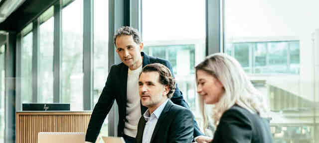 Een groep collega's zijn in een bespreking met elkaar op kantoor bij SRM