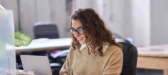 Collega op laptop in een online meeting op kantoor bij Computrain