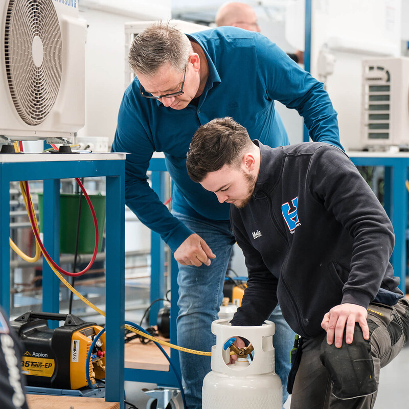Twee medewerkers in een fabriek die werken aan een gaskraan